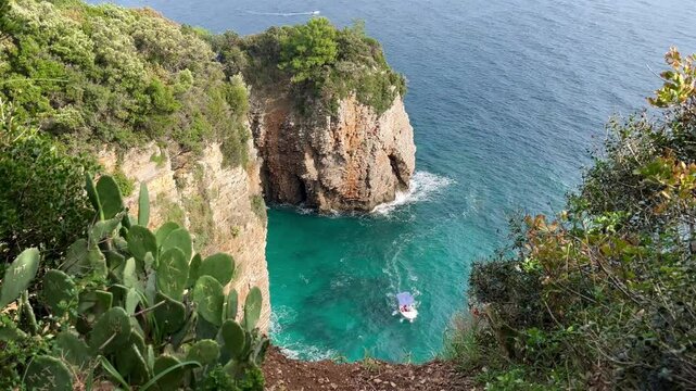 Tourist boat passing by the majestic cliffs of Uvala Na uPloču in Montenegro, tourists enjoying a peaceful day with stunning turquoise waters in October