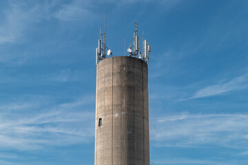 Torre de concreto cilíndrica com várias antenas no topo para conectividade móvel sem fios