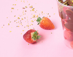Whole fresh strawberries covered with melted liquid chocolate in cup. Sweet food, dessert on pink background. 