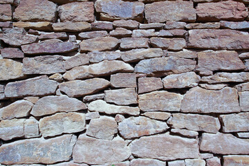 A wall of natural flat stones stacked horizontally. Texture for background.