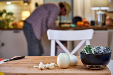 man in the kitchen peeling onions