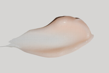 Texture of pink cream on white background. Smear of moisturizer close up. Lotion swatch. Beauty skin care product smear smudge. SPF sunscreen cream sample on color background