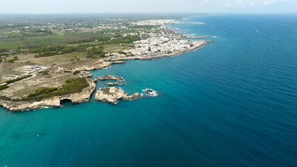 Aerial view of the ruins of a coastal center of the Messapian civilization. It is the archaeological area. In background is the town of ​​Roca Vecchia in the province of Lecce, Salento, Puglia, Italy.