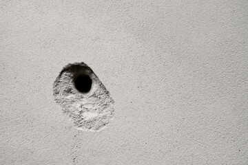 Cracks holes on the cement wall Caused by drilling To put the plumbing tube in the house