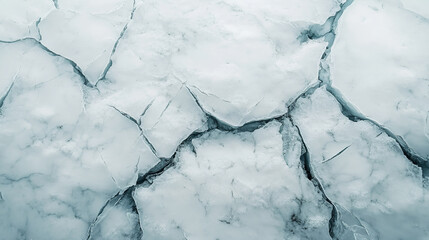 A close-up of deep fractures on a pristine white glacier or frozen lake.