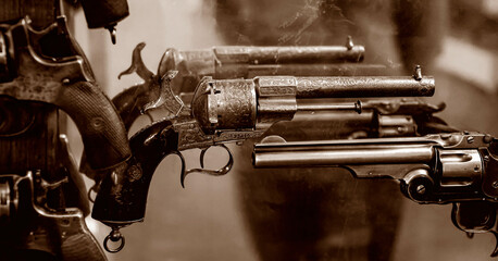 Historical display of antique revolvers showcasing craftsmanship in a dimly lit museum setting