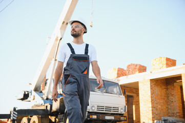 Construction worker in uniform and safety equipment have job on building. Industrial theme