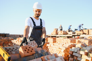 Construction worker in uniform and safety equipment have job on building