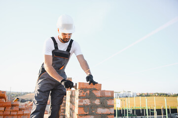 Construction worker man in work clothes and a construction helmet. Portrait of positive male...