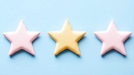 Three Colorful Star-Shaped Cookies on Light Blue Background in a Row