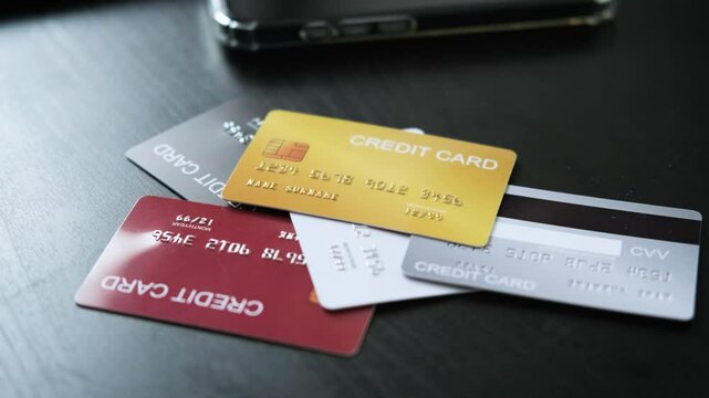 Hand selecting a credit card from multiple options on the table, representing financial flexibility and secure choices for online shopping, e-commerce payments, and digital transactions economy.