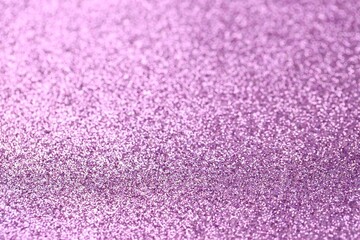 Beautiful purple glitter sparks texture as background with shallow depth of field