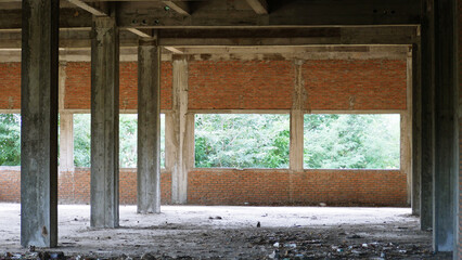 Abandoned building interior with concrete pillars and brick walls