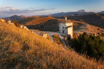 Early morning view of the Santa Maria della Pieta church by Calascio. Idyllic serene scene full of warm sunrise light in the mountains.