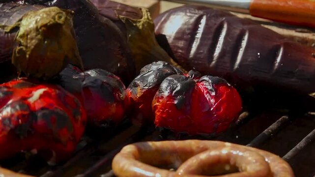 A rustic outdoor scene of vegetables grilling over a wood fire, an essential step in making traditional Romanian zacusca. The fire-roasted vegetables bring out deep, smoky flavors.