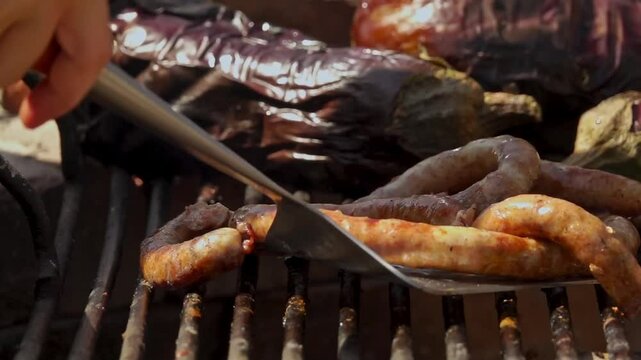 A rustic outdoor scene of vegetables grilling over a wood fire, an essential step in making traditional Romanian zacusca. The fire-roasted vegetables bring out deep, smoky flavors.