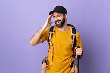 Caucasian handsome man with backpack and trekking poles over isolated background laughing