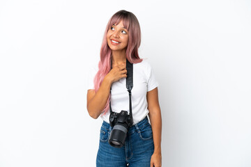 Young photographer mixed race woman with pink hair isolated on white background looking up while smiling