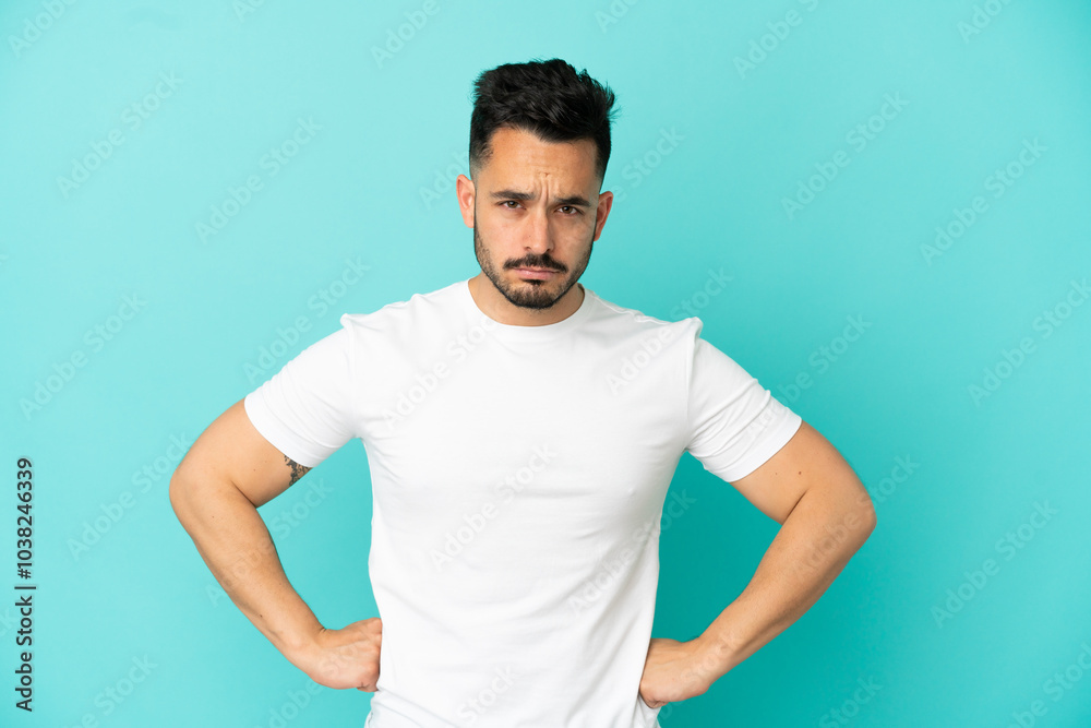 Wall mural young caucasian man isolated on blue background angry