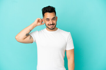 Young caucasian man isolated on blue background laughing