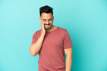 Young caucasian man isolated on blue background with toothache