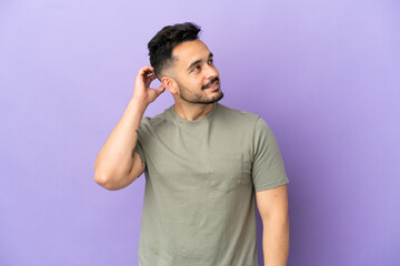 Fototapeta premium Young caucasian man isolated on purple background thinking an idea