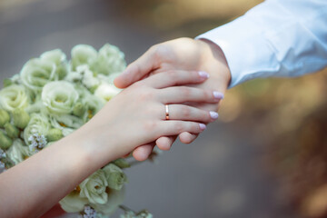 Wedding bouquet in the hands of the bride at the ceremony. Touching the hands of the bride and groom. Hugs of the newlyweds. Future married couple. The tenderness and beauty of the wedding ceremony.