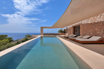 Fototapeta premium Luxury villa with infinity pool overlooking the ocean in a sunny coastal location