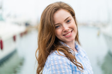 Young redhead woman at outdoors With happy expression