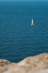Fototapeta premium Small sailboat moves through clear and calm waters near Swedish coast in Baltic sea