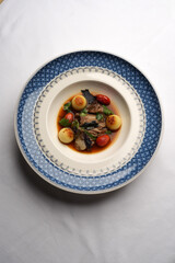 Baked beef sauce with vegetables on plate, close-up