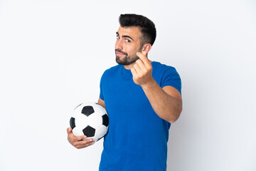 Handsome young football player man over isolated wall making money gesture