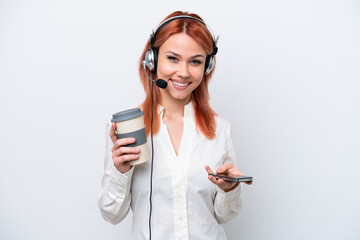 Naklejka premium Telemarketer Russian girl working with a headset isolated on white background holding coffee to take away and a mobile