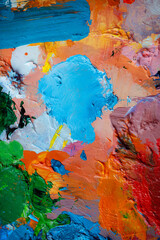 Naklejka premium Colorful abstract texture. Smears of oil paint and a palette knife on an art palette. The concept of the modern school of art. Fragment of creative work. Colors of the year 2025
