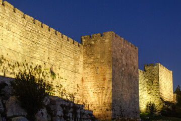 A section of the stone ramparts and walls of the Old City of Jerusalem, illuminated by artificial light at twilight in Israel. © Yehoshua Halevi