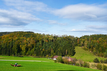 Fototapeta premium A tractor cuts hay on a field,lower austria,Austria