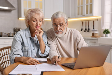 Fototapeta premium Pension savings. Senior couple planning budget at wooden table indoors