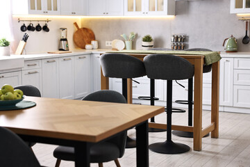 Bar stools, tables and other furniture in stylish kitchen
