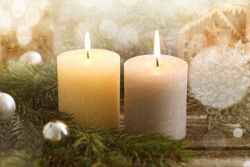 Christmas composition with burning candles on wooden table, bokeh effect. Festive card