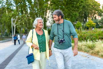 Senior couple visiting a city walking around holding hands