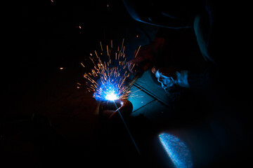 Arc welding. Welding pipes in inert gases. MIG / MAG. A bright flash of light and a sheaf of sparks.