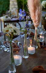Wedding decoration. Floristics. Vessels with candles and bulk wax. Transparency and ease of design. Blue flowers and pampas.
