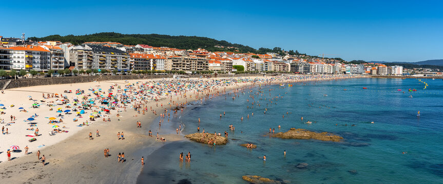Sanjenjo, Spain, August 15, 2024: Silgar Beach packed with tourists on a sunny day in the Ria de Pontevedra, Galicia.