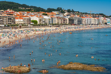 Sanjenjo, Spain, August 15, 2024: Silgar Beach packed with tourists on a sunny day in the Ria de Pontevedra, Galicia.