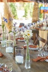 Wedding decoration. Floristics. Vessels with candles and bulk wax. Transparency and ease of design. Blue flowers and pampas.