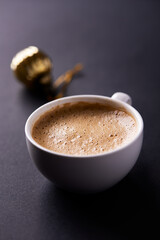 Cup of coffee on dark paper background. Soft focus. Close up. Copy space.	