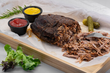 Delicious Pulled Pork served on a Wooden Platter with various Sauces and Pickles