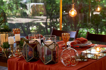 Table setting with orange napkins and glasses. Classic. Warm shades.