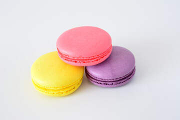 three colorful macarons with a white background macro