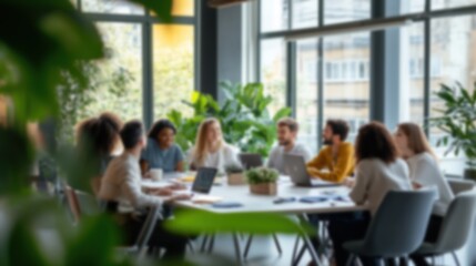 This blurred image captures a group of professionals in a well-lit office, engaged in a collaborative discussion, with plants adding a refreshing, natural touch.